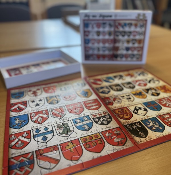 A close up of the jigsaw showing the seventeenth century heraldic shields printed on the jigsaw design