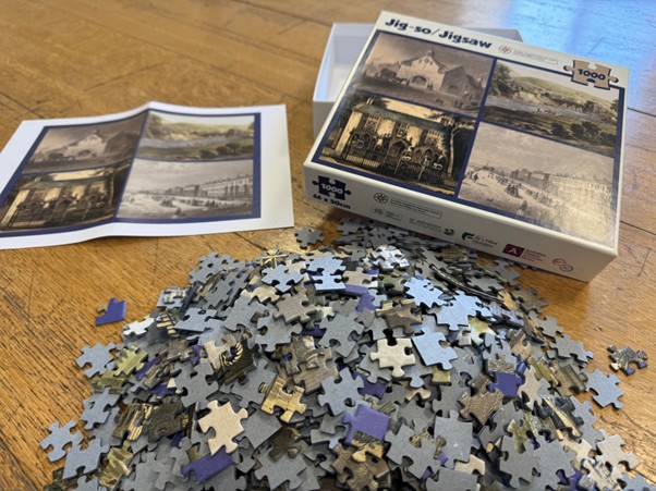 A close up of the jigsaw pieces piled up outside of the box